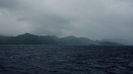 Sailing on a boat around Seychelles island on a foggy day