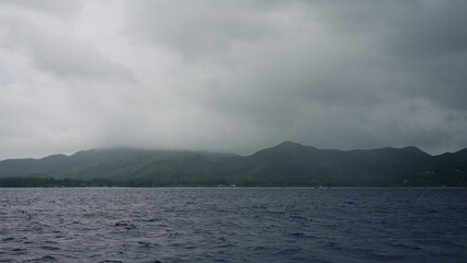 Sailing on a boat around Seychelles island on a foggy day