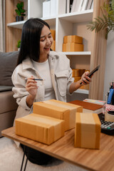 an entrepreneur is packing parcel for order from customer, she own a small business, sme, a lot of...