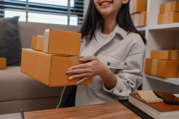 she is packing parcel to send to all customers, this entrepreneur own a small business, sme,...