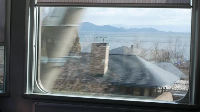 landscape view inside train commuter through train window with view of local suburb countryside area in Kyoto with Biwa lake view. train transportation view from inside train