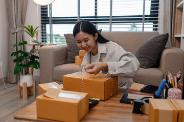 she is packing parcel to send to all customers, this entrepreneur own a small business, sme, selling product online, she prepare her product in her office, packing order
