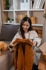 she is happily packing products into boxes to be sent to customers, an entrepreneur is preparing products to be sent to buyers, parcel, sme, package, small business, preparation