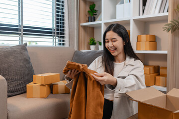 she is happily packing products into boxes to be sent to customers, an entrepreneur is preparing products to be sent to buyers, parcel, sme, package, small business, preparation