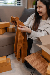 she is happily packing products into boxes to be sent to customers, an entrepreneur is preparing products to be sent to buyers, parcel, sme, package, small business, preparation