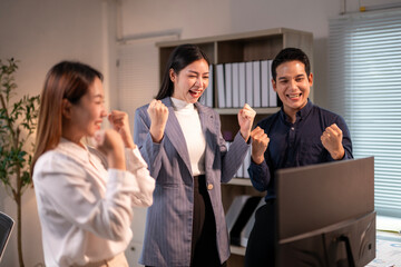 Three people are standing in front of a computer monitor