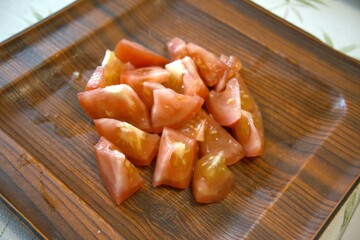 Sliced tomato on wooden tray