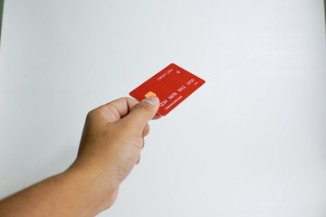 Close up of hand with red credit card isolated on white background. Shopping, finance and people concept