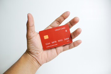 Close up of hand with red credit card isolated on white background. Shopping, finance and people concept