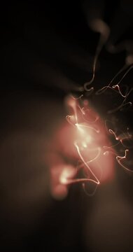 Sparkles trail moving and shining with black background. Loop. 4K Vertical
