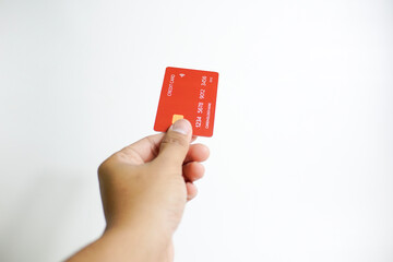 Close up of hand with red credit card isolated on white background. Shopping, finance and people concept