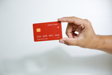 Close up of hand with red credit card isolated on white background. Shopping, finance and people concept