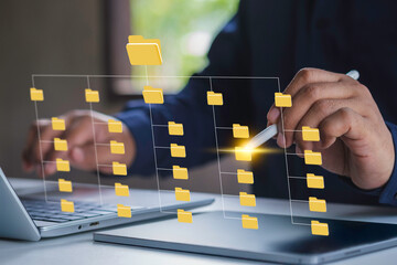 Systematic data storage for ease of use. Folder hierarchy structure and document management system DMS. Businessman using laptop computer and tablet for saving and classifying files.