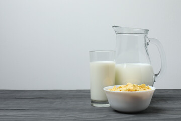 jug of milk, cornflakes on wooden background