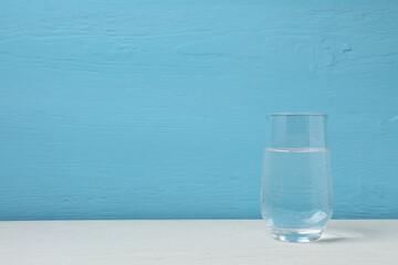 a glass of water on wooden table.