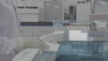 Biotechnology Instrumental Immunochemistry laboratory with scientist in white Coat safety glove handling Test Tubes. Putting Them Inside Advanced Machine for Analysis in centrifuge laboratory setting - Powered by Adobe