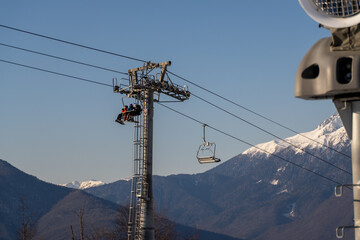 Skiers Chairlift Mountains: Winter transportation, skiers ascending chairlift in snowy mountains.