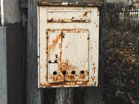 Rusty vintage mailbox in an outdoor rustic setting.
