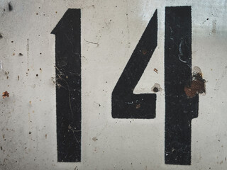 Bold number 14 on weathered concrete background.