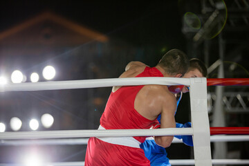 Boxing fight of two athletes in gloves in the ring