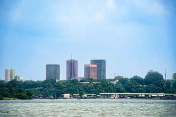 Abidjan skyline seen from the Ébrié lagoon – Modern tower and lush vegetation