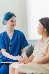 An elderly Asian woman visits the doctor and talks to the doctor about her illness in the clinic.
