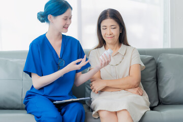 An elderly Asian woman visits the doctor and talks to the doctor about her illness in the clinic.