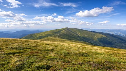 Fototapeta premium A lush green mountain landscape under a blue sky with scattered clouds, offering a panoramic and serene natural view.