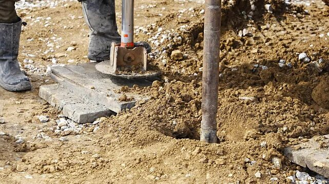 Close-up of soil sampling during pile drilling process. Extraction of subsurface material for geotechnical analysis and foundation assessment