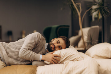 Man Relaxing on Comfortable Bed in Modern Stylish Interior Setting