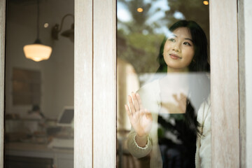 Peaceful scene of a woman daydreaming by the window inside a stylish cafe