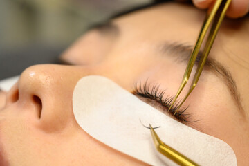 Detailed view of technician placing eyelash extensions on a client