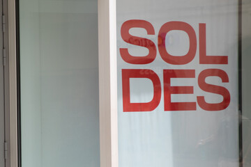 sale means soldes in french text red sign on windows storefront
