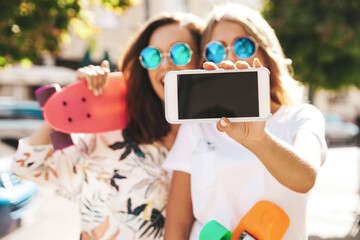 Two young female stylish hippie brunette and blond women models in summer sunny day in hipster...
