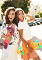 Two young stylish smiling hippie brunette and blond women models in summer sunny day in hipster...