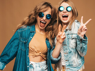 Two young beautiful smiling hipster female in trendy summer clothes and sunglasses. Sexy carefree...