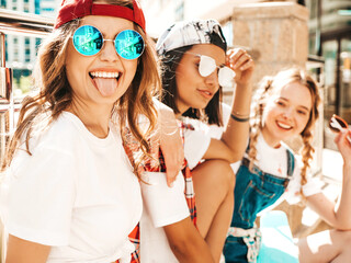 Portrait of three young beautiful smiling hipster female in trendy summer clothes. carefree women...