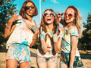 Three happy beautiful female making party at Holi colors festival in summer time.Young smiling...