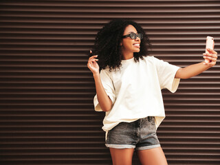Beautiful woman with afro curls hairstyle.Smiling hipster model in white t-shirt. Sexy carefree...