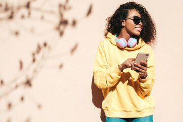 Beautiful woman with afro curls hairstyle.Smiling model in yellow hoodie. Sexy carefree female...
