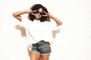 Beautiful woman with afro curls hairstyle.Smiling hipster model in white t-shirt. Sexy carefree...
