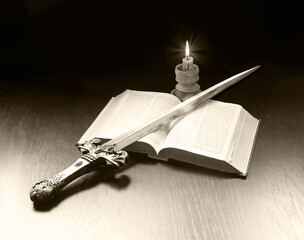 Old book and sword on the table