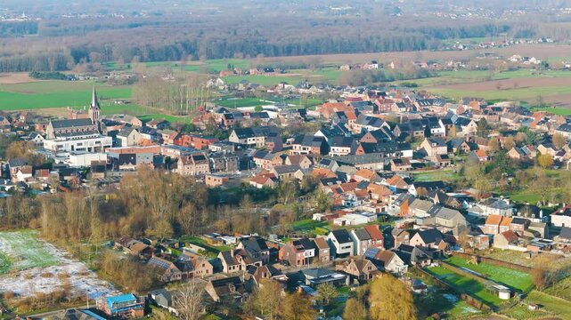 village peizegem belgium green farming fields beautiful homes old church yellow trees amidst snow winter scenic urban area long side aerial view 