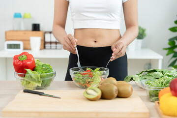 slim body women choose healthy foods, dieting female mixing salad on kitchen for diet. Good healthy...