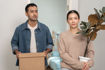 Moving house, relocation. Couples hold carton box and decorate contain equipment for new...