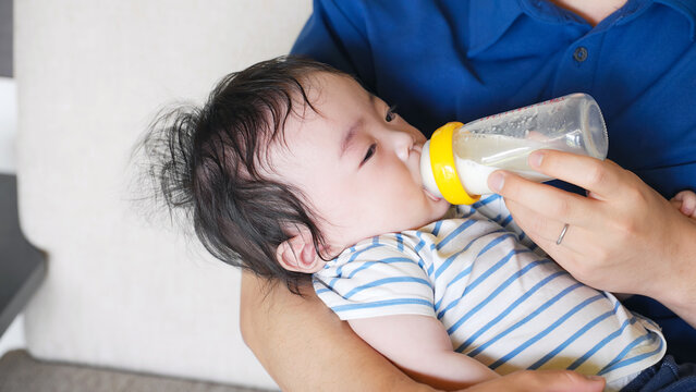 A man feeding a baby with a bottle