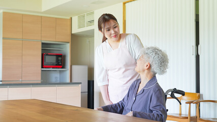 ケアスタッフからサポートを受ける車椅子に乗ったシニア女性