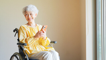Senior woman in a wheelchair using a smartphone