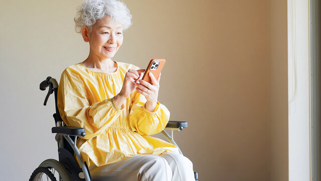 シニア、スマホ、スマートフォン、車椅子、女性、アプリ、車いす、高齢者、障害者、お年寄り、バリアフリー、情報、ニュース、マップ、検索、SNS、ソーシャルメディア、調べる、イベント、おばあちゃん、シルバー、保険、申し込み、手続き、電子化、DX、デジタル、メール、メッセージ、チャット、笑顔、介護、連絡、見守り、便利、機能、デイサービス、サポート、支援、タッチ、操作、日本人、60代、70代、福祉、施設、老
