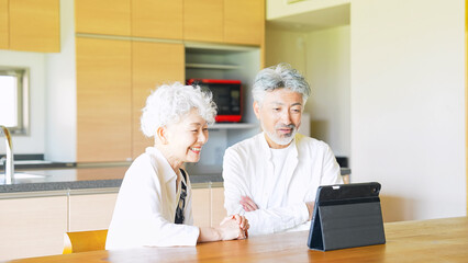 一緒にタブレットを見るシニアカップル